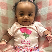 Anayah joined the competition — help win amazing prizes! baby, child, girl, smiling, curly_hair, pink_bows, bracelet, shirt, flower_design, blanket, pink, white, colorful_pants, lying_down, infant, cute, happy, indoors, portrait, adorable