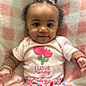 baby, child, girl, smiling, curly_hair, pink_bows, bracelet, shirt, flower_design, blanket, pink, white, colorful_pants, lying_down, infant, cute, happy, indoors, portrait, adorable
