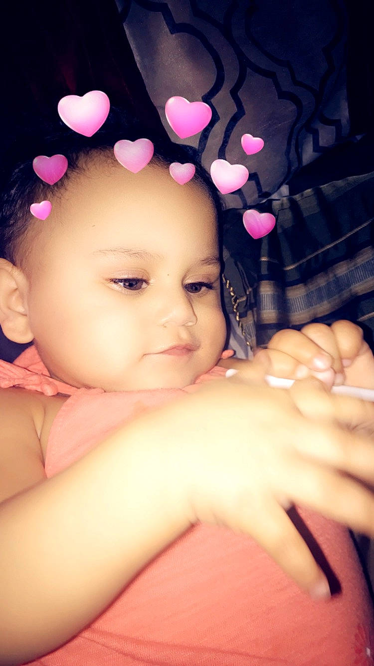 Sophia is registered to the contest to win money with this photo: beauty, black_hair, cheek, child, ear, face, finger, gesture, hand, head, lip, nail, person, petal, pink, skin, thumb, toddler