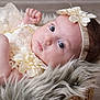 baby, infant, face, headband, lace, flower, basket, fur, soft_texture, closeup, portrait, cute, child, newborn, skin, expression, laying_down, indoors, clothing, peaceful