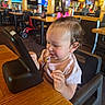 Ameerah is registered to the contest to win money with this photo: child, toddler, baby, girl, restaurant, high_chair, pink_bow, hair, sitting, table, indoors, dining, curious, face, portrait, wooden_table, chairs, menu, television, family_dining