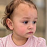 child, toddler, portrait, face, girl, pink, bow, hair, earring, shirt, floral_pattern, close_up, indoor, serious_expression, looking_away, brown_hair, blue_eyes, baby, fashion, photography
