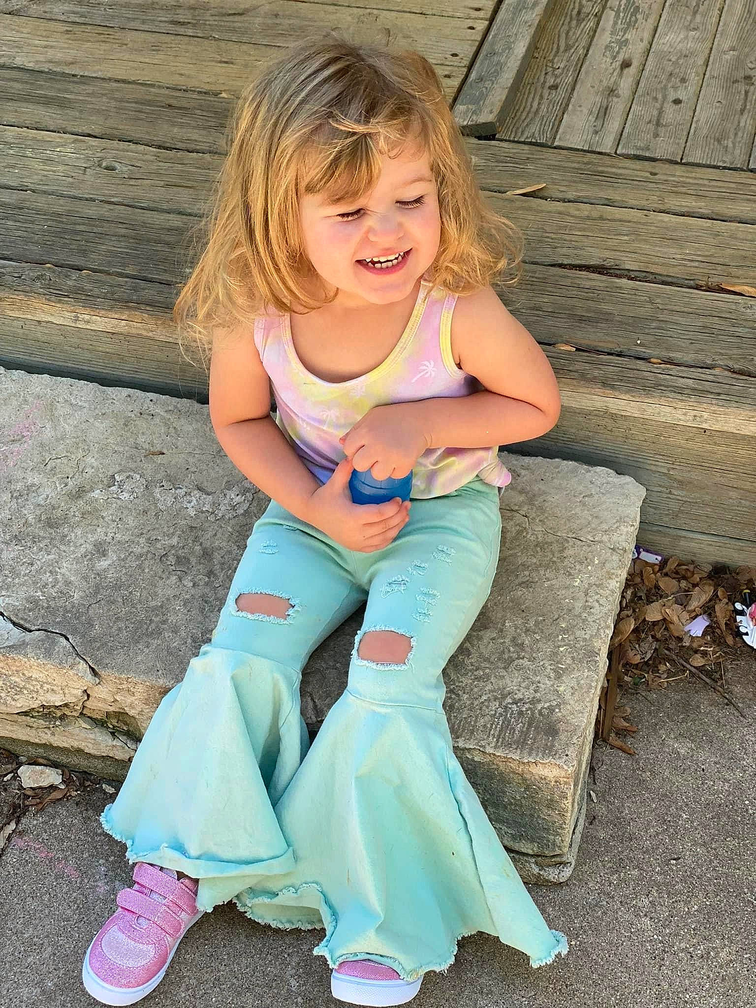 Skarlett is registered to the contest to win money with this photo: child, face, facial_expression, fun, grass, happy, head, human_body, joint, joy, knee, leisure, long_hair, people_in_nature, person, pink, smile, summer, thigh, toddler