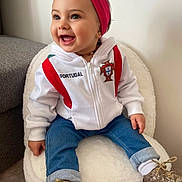 María a rejoint le concours — aidez-le/la à gagner de superbes lots ! baby, boots, chair, child, country_emblem, cute, earring, fuzzy_chair, headband, hoodie, indoor, jeans, necklace, portrait, portugal_jacket, sitting, smiling, sparkly_shoes, toddler, white_wall