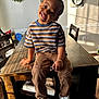 Myles joined the competition — help win amazing prizes! child, toddler, smiling, striped_shirt, brown_pants, white_sneakers, toy, wooden_table, dining_room, chairs, wreath, decorative_plates, sunlight, home_interior, happy, portrait, casual_clothing, playful, indoor, person
