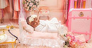 Vienna is registered to the contest to win money with this photo: baby, infant, sleeping, portrait, swaddled, white_blanket, headband, flower, pink, vintage, telephone, suitcase, nursery, lace, cushion, soft_lighting, indoor, decorative, photography, peaceful