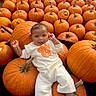 Vienna is registered to the contest to win money with this photo: baby, child, infant, pumpkins, pumpkin_patch, outdoor, autumn, fall, orange, portrait, sitting, lying_down, smiling, happy, baby_clothing, white_outfit, socks, nature, harvest, seasonal