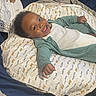Jamar joined the competition — help win amazing prizes! baby, smiling, pillow, patterned, green_clothing, white_clothing, infant, lying_down, happy, face, child, indoor, bed, blanket, cute, portrait, head, person, cozy, comfort