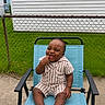 baby, child, smiling, outdoor, chair, striped_clothing, grass, fence, happy, person, infant, playful, sitting, casual, daylight, concrete, backyard, cute, portrait, expression