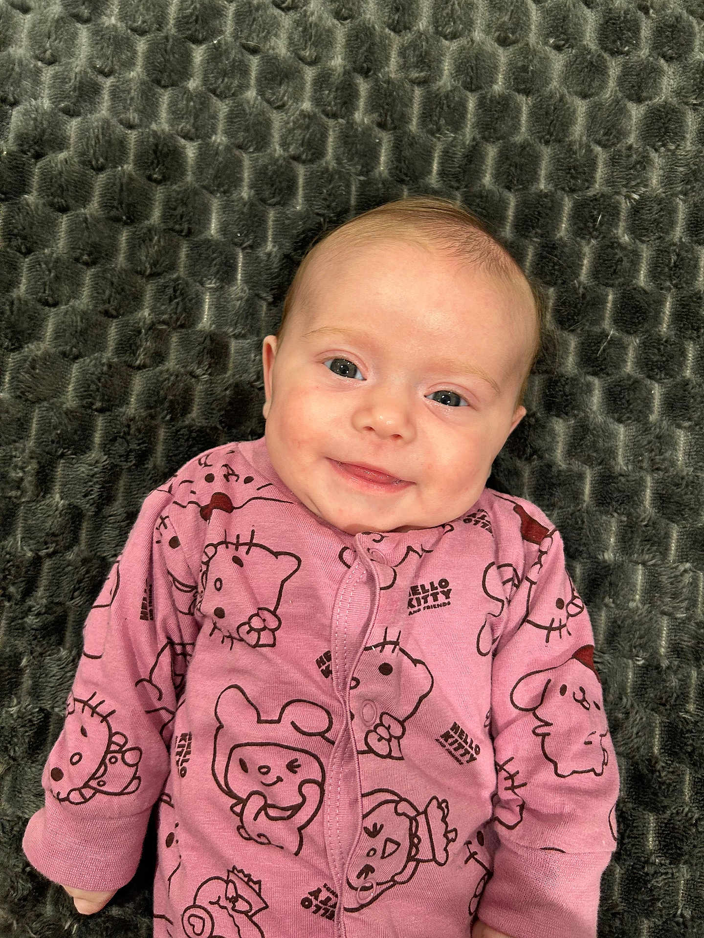 élya participe au concours pour gagner de l'argent avec cette photo : baby, blanket, child, cozy, cute, expressive_eyes, face, happy, hello_kitty, indoors, infant, lying_down, onesie, pink_clothing, portrait, small_hands, smiling, soft_fabric, texture, young_child