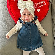 élya participe au concours pour gagner de l'argent avec cette photo : baby, bow, child, clothing, cozy, cute, denim_dress, gray_blanket, happy, headwear, indoors, infant, lying_down, one_person, portrait, red_heart_pillow, smiling, soft_texture, white_tights, white_turban