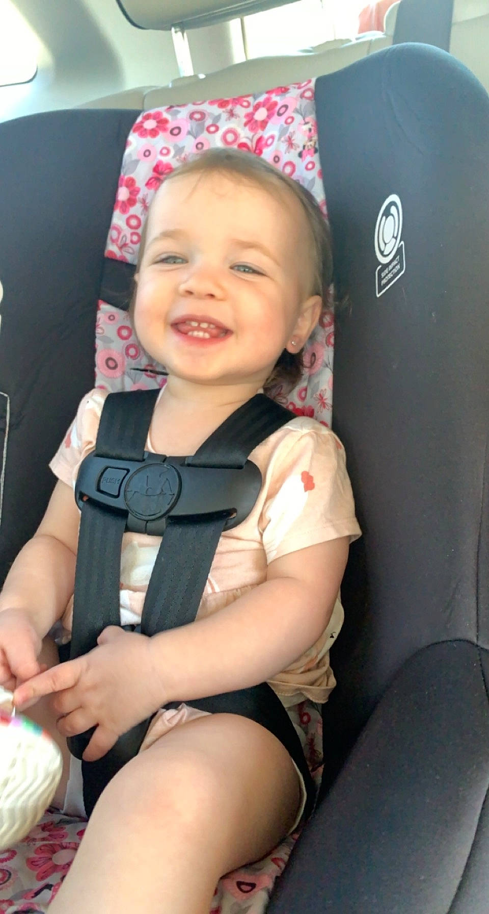 Lizzie is registered to the contest to win money with this photo: auto_part, baby, baby_carriage, baby_in_car_seat, baby_products, baby_toddler_clothing, car_seat, child, comfort, face, fun, happy, joy, person, product, seat_belt, sitting, skin, smile, steering_wheel