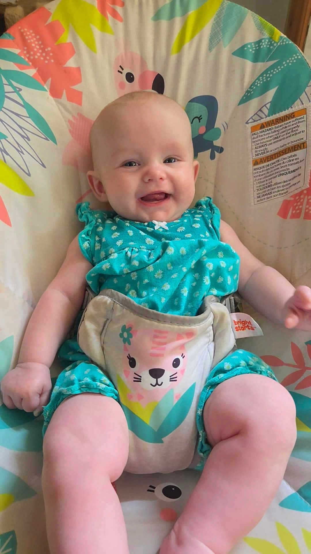 Kaÿla is registered to the contest to win money with this photo: baby, smiling, sitting, baby_seat, colorful, clothing, child, cute, happy, infant, patterned, playful, portrait, seat, small_child, toddler, wearing, young, blue, indoor