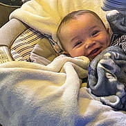 Earnan joined the competition — help win amazing prizes! baby, blanket, child, clothing, comfort, cozy, cute, face, happy, indoors, infant, pillow, portrait, resting, seat, smile, soft, striped, warm, young