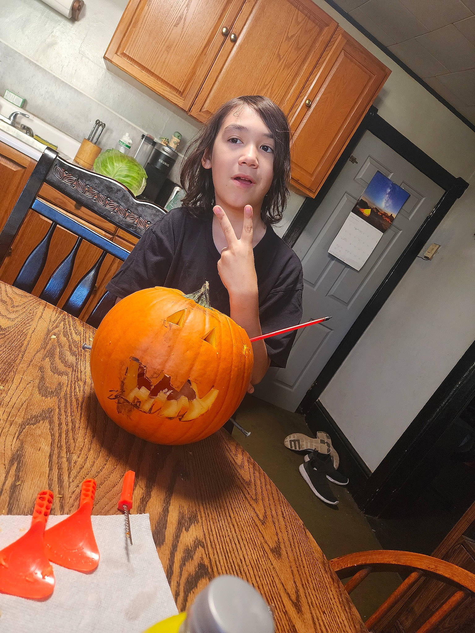 Ian is registered to the contest to win money with this photo: cabinetry, calabaza, chair, countertop, cucurbita, flooring, food, gourd, home_appliance, kitchen, kitchen_appliance, natural_foods, orange, person, pumpkin, squash, table, tableware, vegetable, winter_squash