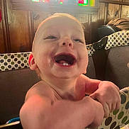 Atlas is registered to the contest to win money with this photo: baby, smiling, infant, playpen, polka_dot, wood_paneling, stained_glass, happy, child, indoor, cute, face, arms, teeth, furniture, person, young, expression, joy, closeup