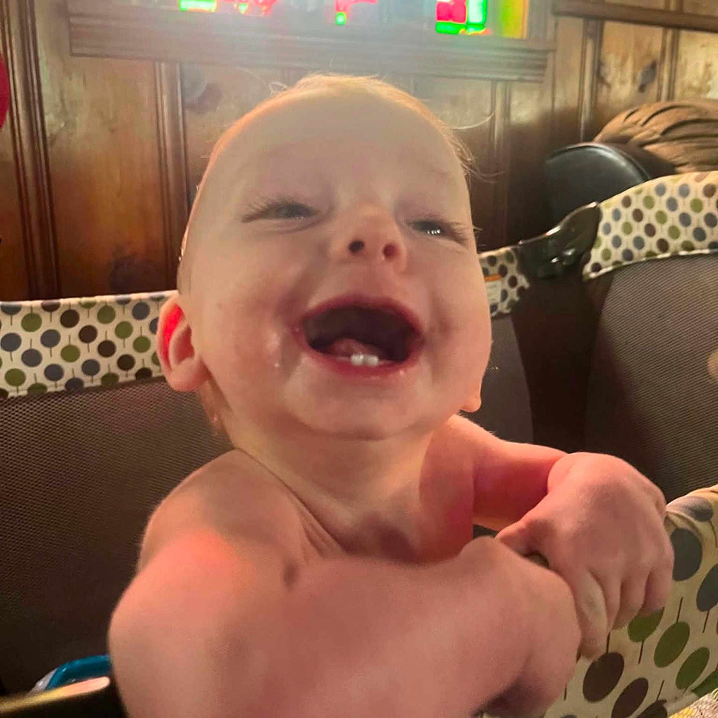 Atlas is registered to the contest to win money with this photo: baby, smiling, infant, playpen, polka_dot, wood_paneling, stained_glass, happy, child, indoor, cute, face, arms, teeth, furniture, person, young, expression, joy, closeup