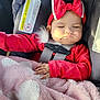 baby, child, car_seat, red_clothing, headband, bow, blanket, sleeping, closed_eyes, infant, hand, soft_texture, pink_blanket, car_interior, seatbelt, cute, peaceful, portrait, young_child, safety