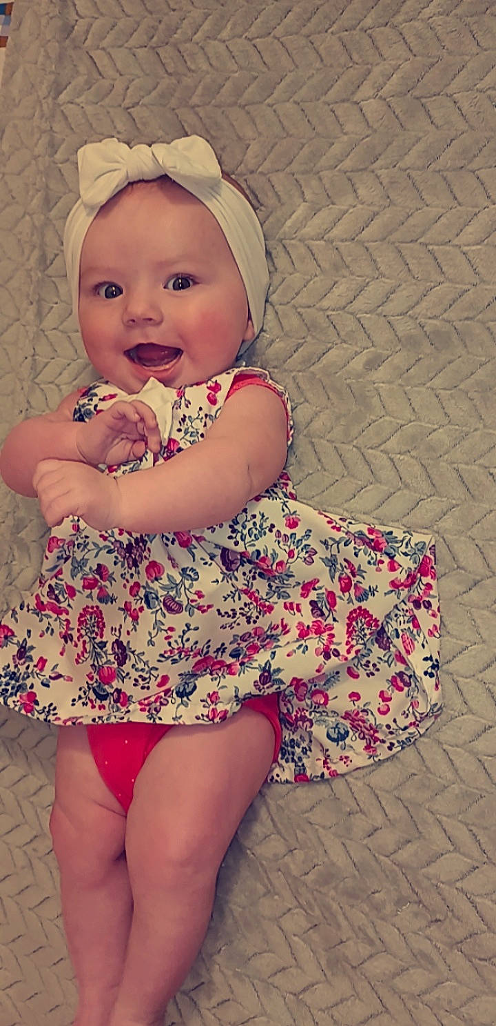 Maelia a rejoint le concours — aidez-le/la à gagner de superbes lots ! baby, baby_toddler_clothing, day_dress, dress, eye, face, facial_expression, happy, head, headwear, human_body, iris, lip, one_piece_garment, person, pink, skin, sleeve, smile, thigh