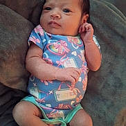 Grace is registered to the contest to win money with this photo: baby, infant, onesie, blanket, cute, cozy, child, person, newborn, lying_down, soft_texture, colorful_clothing, pink, blue, small_hands, expression, indoors, resting, portrait, young