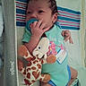 Grace joined the competition — help win amazing prizes! baby, pacifier, plush_toy, giraffe, onesie, striped_blanket, infant, hand, face, sleeping_area, fabric, cute, child, lying_down, indoors, soft_toy, newborn, clothing, baby_gear, resting
