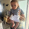 baby, child, infant, portrait, being_held, wide_eyes, serious_expression, striped_shirt, suspenders, white_shorts, indoor, home, kitchen, doorway, window, sunlight, adult, arms, furniture, photography
