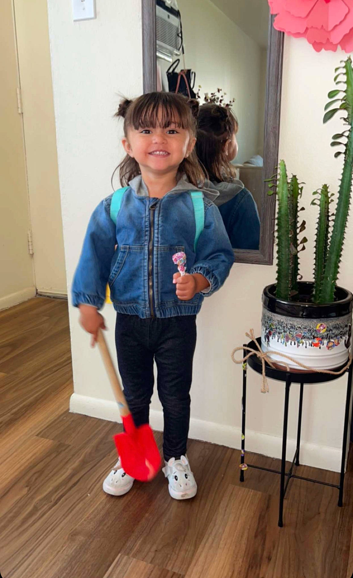 Adele is registered to the contest to win money with this photo: baby_toddler_clothing, child, denim, door, electric_blue, flooring, flowerpot, hardwood, houseplant, joy, laminate_flooring, person, plant, room, sleeve, smile, terrestrial_plant, toddler, white, wood