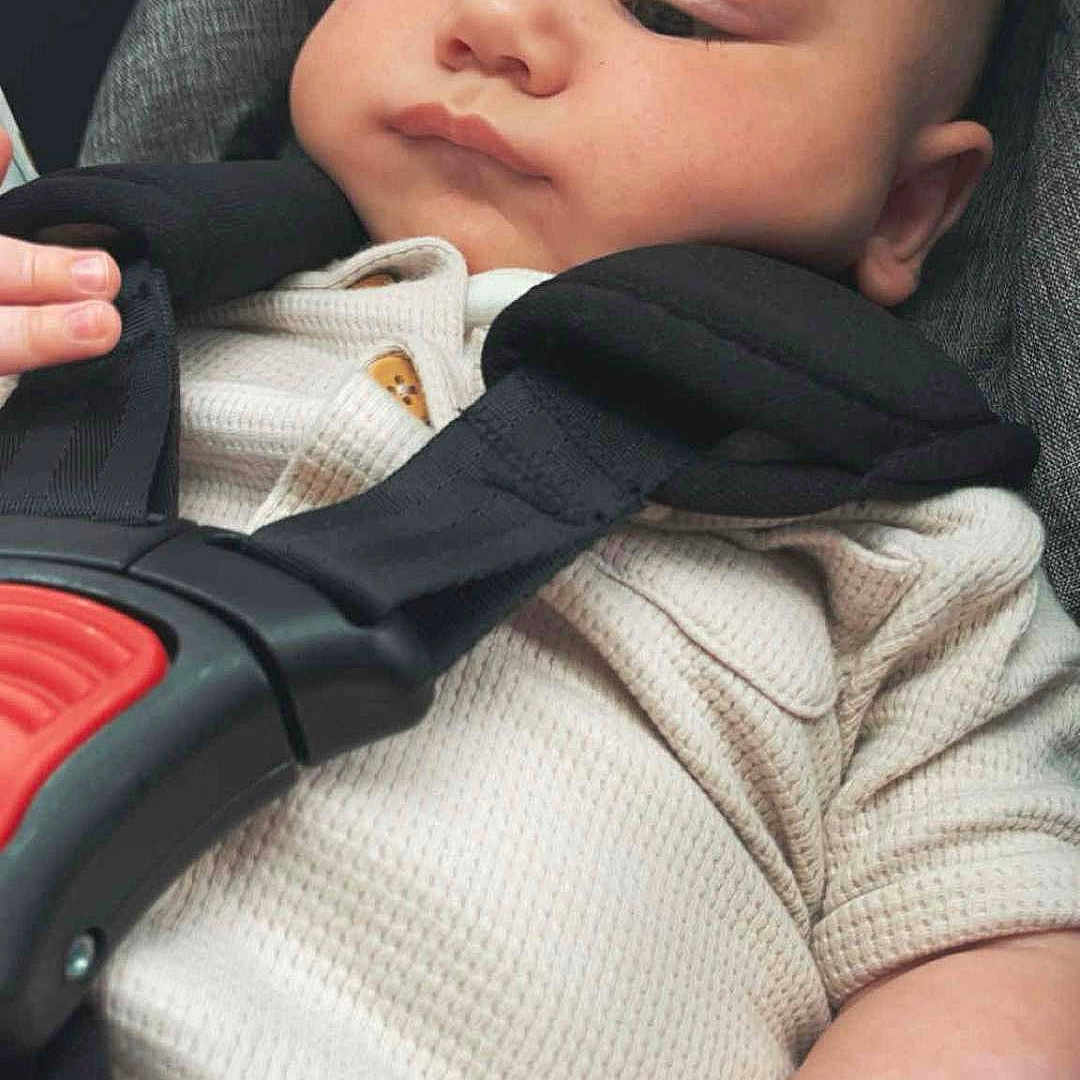 Oakley is registered to the contest to win money with this photo: baby, car_seat, child, closeup, clothing, cute, expression, face, hand, indoor, infant, person, portrait, relaxed, safety, seatbelt, sitting, soft, straps, young