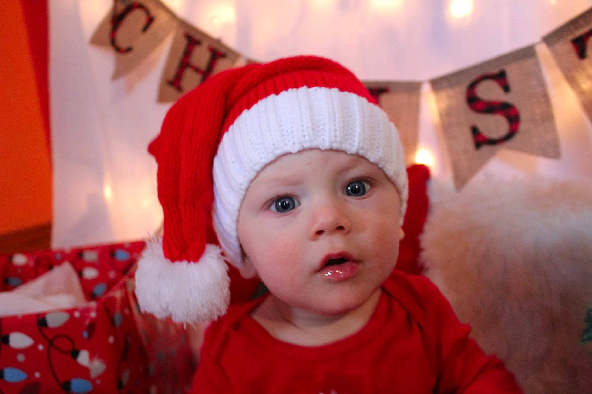 Malachi joined the competition — help win amazing prizes! baby, baby_toddler_clothing, child, christmas, christmas_eve, costume_hat, event, face, fictional_character, fun, fur, happy, headgear, headwear, holiday, person, red, room, surprise, toddler