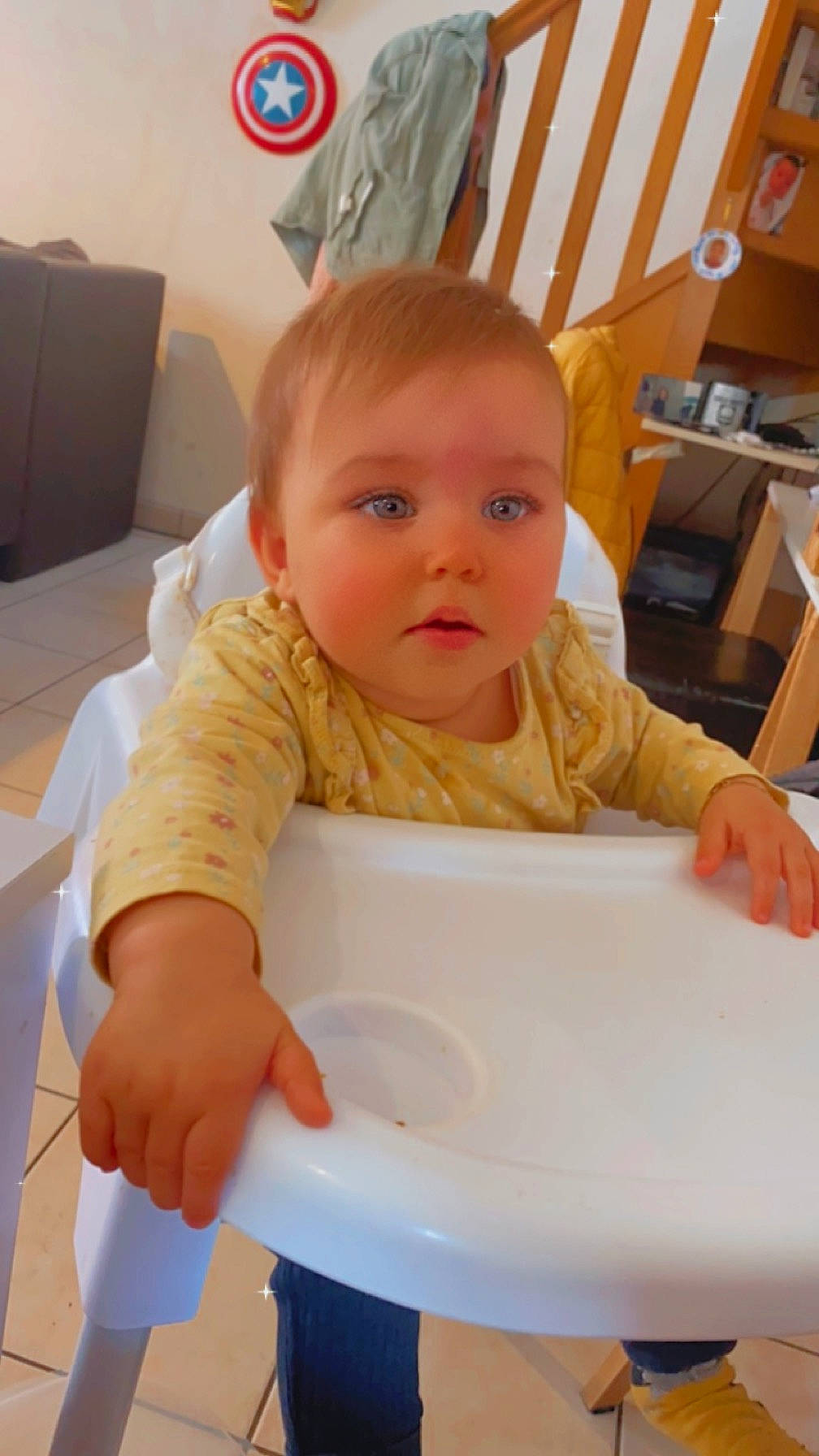 Alba participe au concours pour gagner de l'argent avec cette photo : baby, baby_grabbing_for_something, baby_toddler_clothing, bib, chair, child, comfort_food, flooring, food_craving, fun, meal, person, room, sitting, sleeve, standing, t_shirt, table, toddler, wood