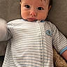 Beau is registered to the contest to win money with this photo: baby, infant, onesie, striped_clothing, face, eyes, arm, couch, blanket, indoor, person, child, cute, young, portrait, soft_texture, comfortable, expression, cozy, hair