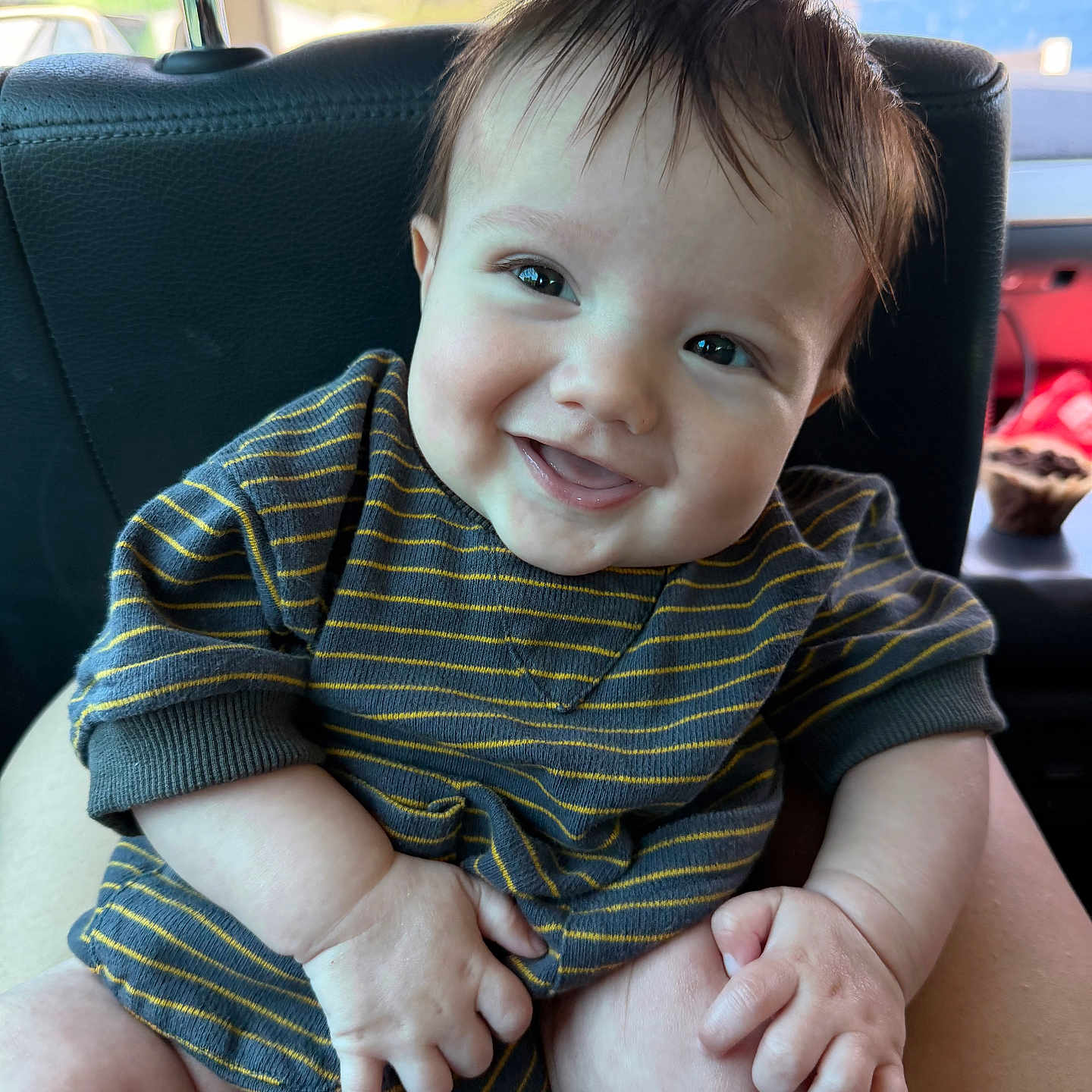 Beau joined the competition — help win amazing prizes! baby, child, smiling, happy, striped_clothing, infant, cute, portrait, sitting, hands, face, person, indoors, car_seat, head, skin, eyebrows, eyelashes, natural_light, young