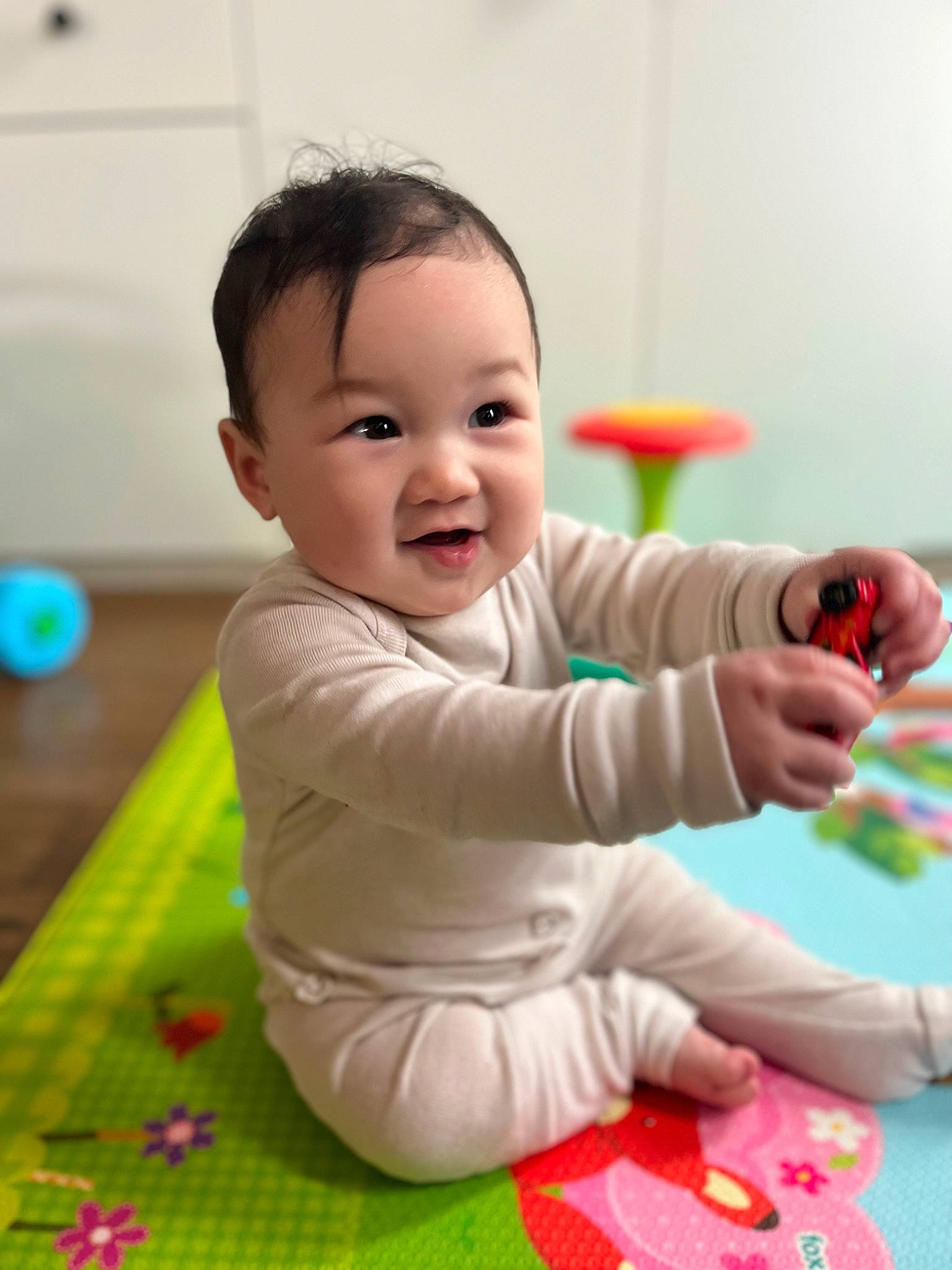 Emma joined the competition — help win amazing prizes! baby, baby_playing_with_toys, baby_toddler_clothing, cheek, child, facial_expression, finger, flooring, fun, gesture, happy, head, leisure, person, play, sitting, skin, sleeve, smile, standing