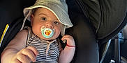 Milan is registered to the contest to win money with this photo: baby, car_interior, car_seat, child, child_seat, comfort, cute, face, hand, hat, indoors, infant, pacifier, person, plush_toy, seatbelt, striped_clothing, sun_hat, winnie_the_pooh, young_child