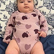 Leya participe au concours pour gagner de l'argent avec cette photo : arms, baby, bed, calm, child, chubby, cute, face, floral_pattern, heart_pattern, indoors, infant, legs, love_text, lying_down, onesie, person, pillow, skin, soft_lighting