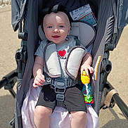 Krimson is registered to the contest to win money with this photo: baby, blanket, blue_eyes, casual, child, clothing, comfort, happy, harness, headband, infant, outdoor, person, play, seat, shoes, smile, stroller, sunlight, toy