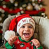 baby, child, smiling, christmas, holiday, santa_hat, festive_clothing, high_chair, happy, portrait, indoors, celebration, cute, infant, toothy_grin, red, green, seasonal, family, joy