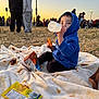 Erick joined the competition — help win amazing prizes! child, toddler, blue_hoodie, bottle, snack, cheese_puffs, blanket, outdoor, sunset, crowd, grass, picnic, food, people, casual_clothing, daylight, relaxing, seated, park, event