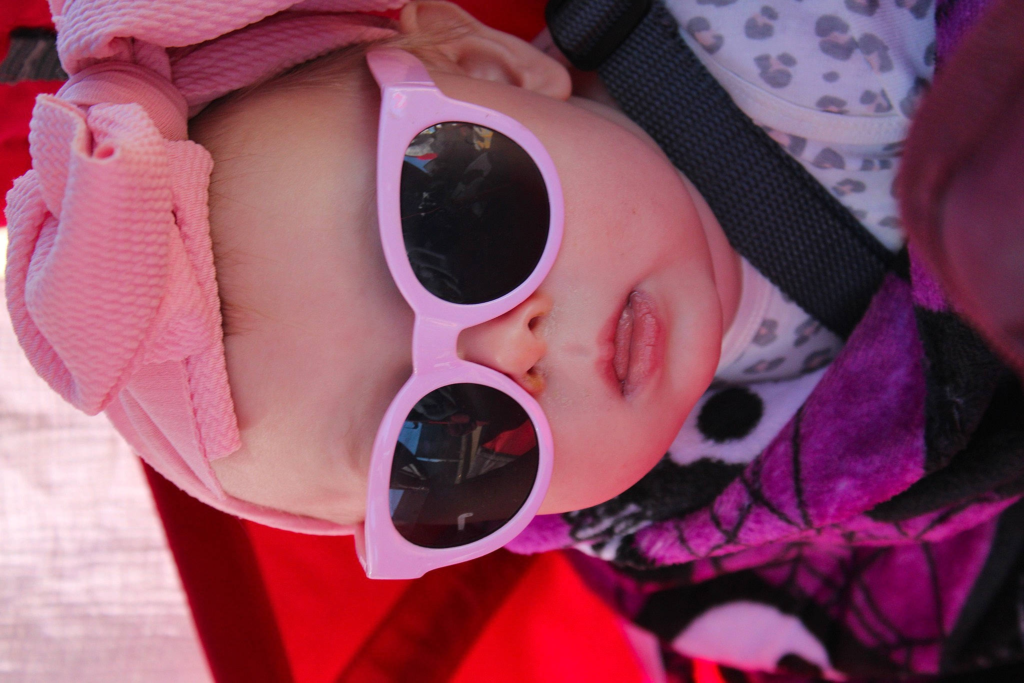 Clarice is registered to the contest to win money with this photo: baby, baby_toddler_clothing, cheek, eyelash, eyewear, finger, glasses, goggles, head, headgear, headwear, lip, person, personal_protective_equipment, pink, purple, skin, sleeve, sunglasses, textile