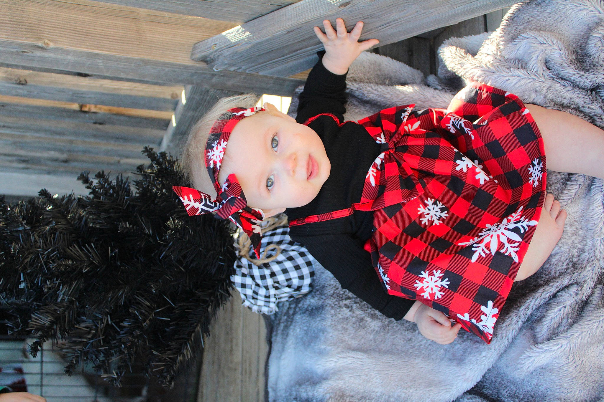 Clarice is registered to the contest to win money with this photo: baby, baby_toddler_clothing, carmine, child, fun, fur, grass, happy, hat, headwear, pattern, person, plaid, sitting, sleeve, smile, tartan, textile, toddler, tree