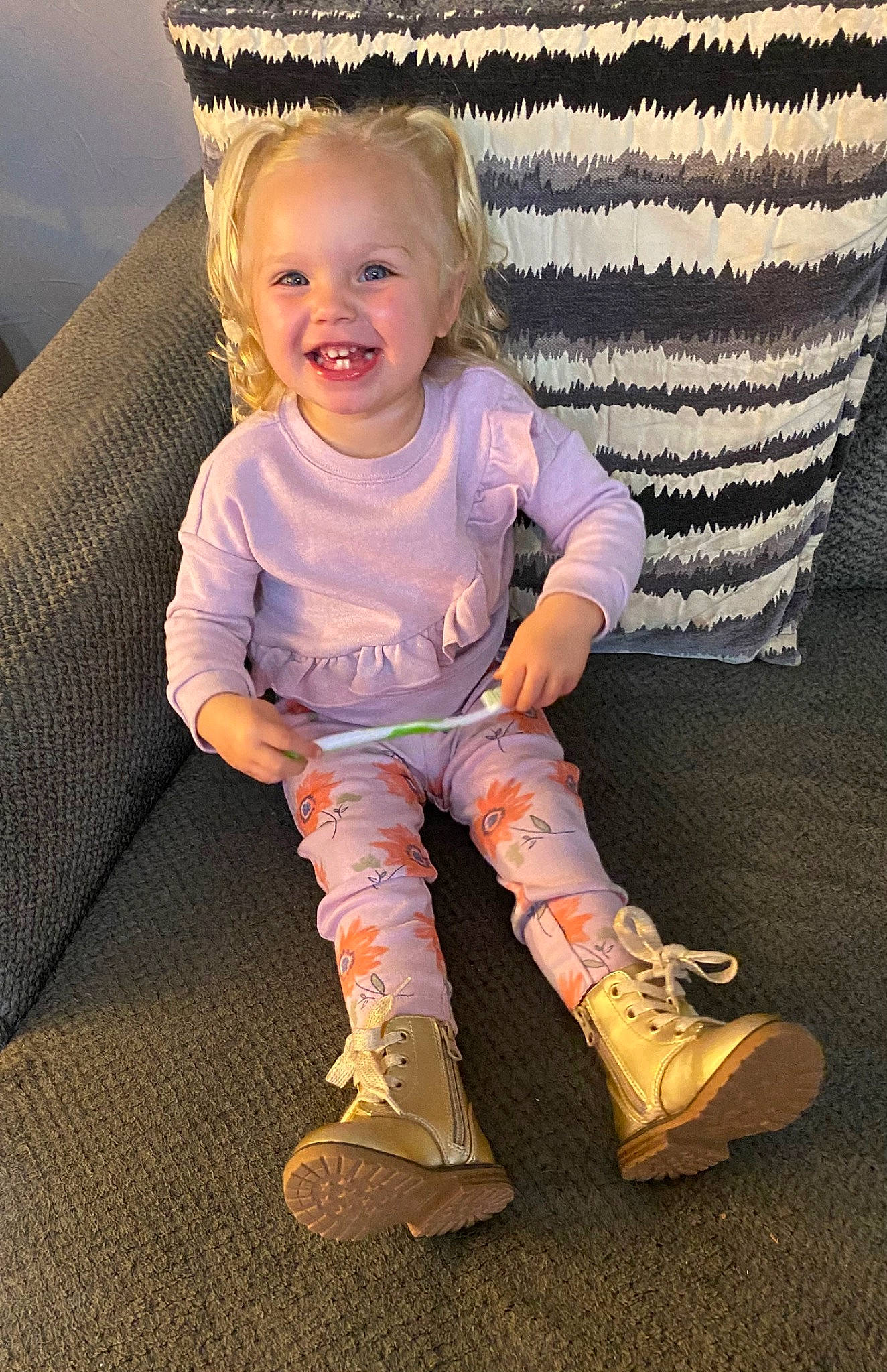Raelee is registered to the contest to win money with this photo: arm, baby_toddler_clothing, cool, couch, eye, face, footwear, hair, happy, human_body, joy, knee, outerwear, person, shoe, sleeve, smile, sneakers, sock, t_shirt