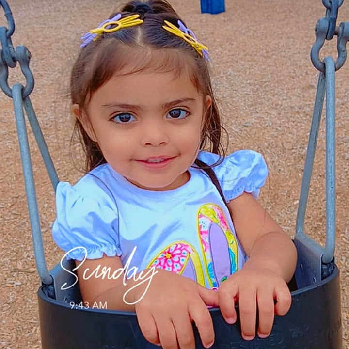 Issbel is registered to the contest to win money with this photo: child, clothing, dress, face, female, girl, grass, head, nature, outdoorplayarea, outdoors, park, person, photography, plant, playarea, portrait, sitting, swing, toy