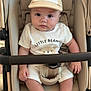 baby, baby_accessories, baby_clothing, beige, cap, child, clothing, cute, eyes, face, footwear, hands, hat, indoor, infant, legs, neutral_colors, portrait, sitting, stroller