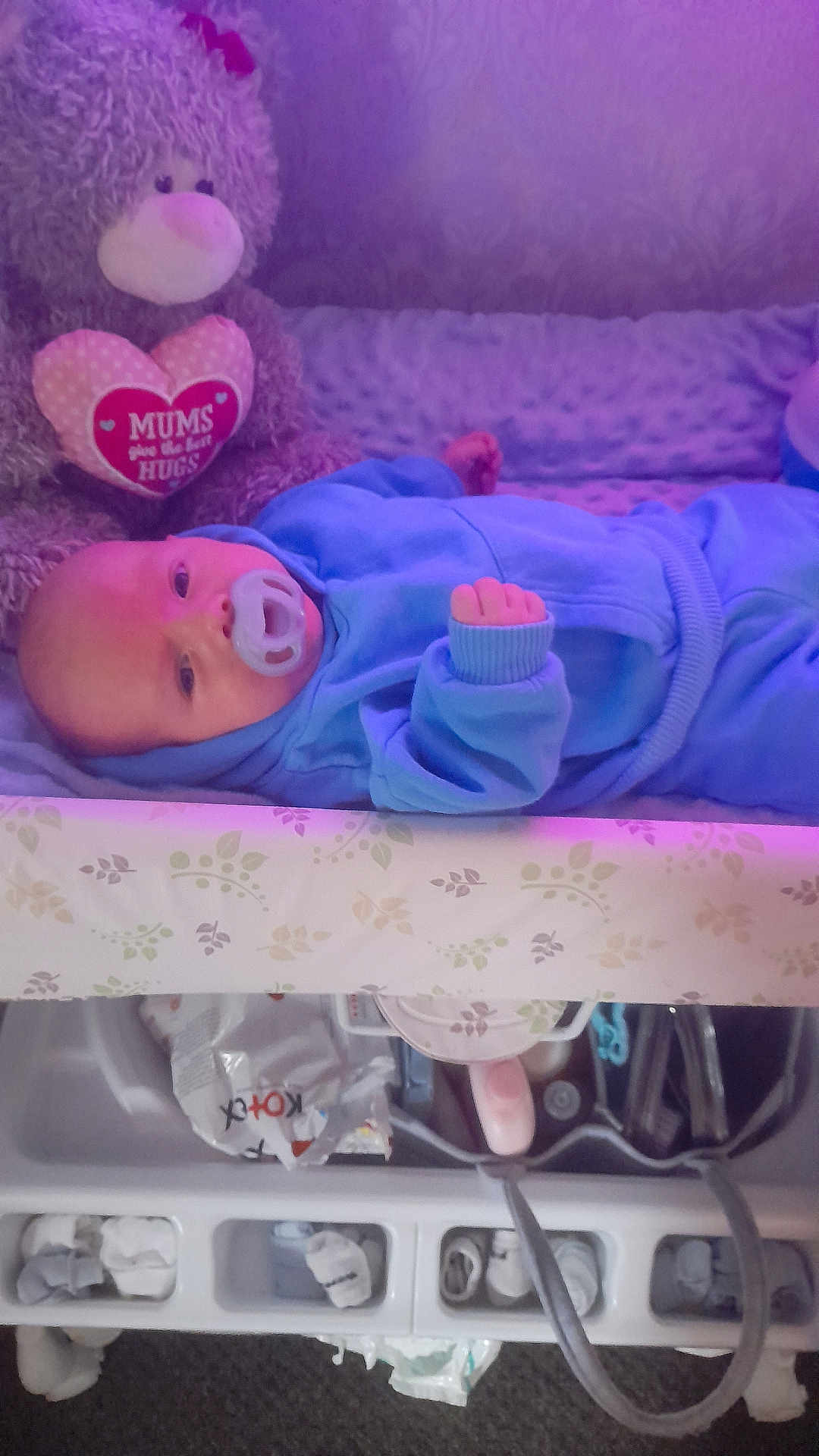 Reggie is registered to the contest to win money with this photo: baby, pacifier, crib, teddy_bear, plush_toy, blue_clothing, infant, bed, soft_toy, sleeping_area, baby_gear, child, cute, comfort, indoor, nursery, childcare, resting, toy, blanket