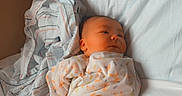 Easton is registered to the contest to win money with this photo: abdomen, baby, baby_products, baby_sleeping, baby_toddler_clothing, bed, bedding, bedtime, child, comfort, foot, human_leg, leg, linens, nap, room, sitting, skin, thigh, toddler