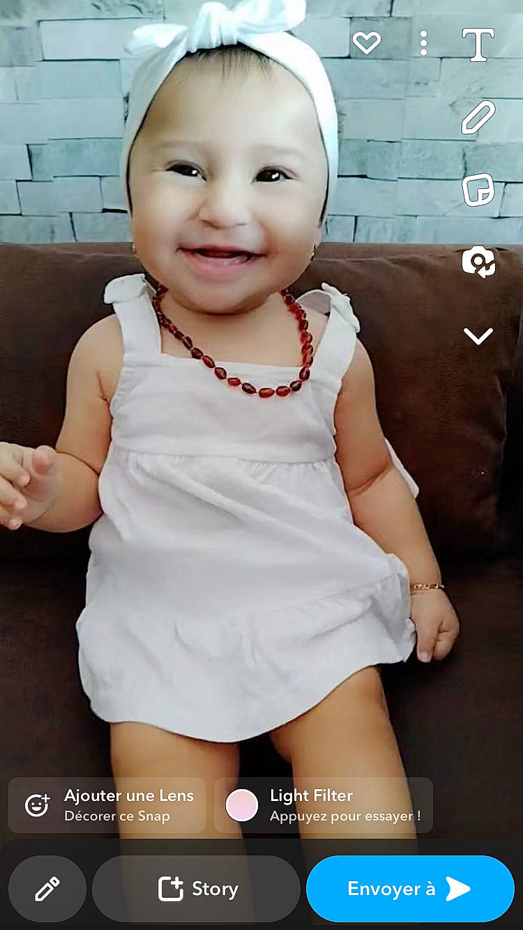 Hanaë participe au concours pour gagner de l'argent avec cette photo : baby, baby_toddler_clothing, cheek, chest, child, fashion_accessory, flash_photography, gesture, happy, human_leg, joy, lip, magenta, person, sitting, skin, sleeve, smile, t_shirt, thigh