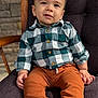 Lucas joined the competition — help win amazing prizes! toddler, child, smiling, shirt, plaid, pants, brown, green, chair, cushion, wood, stone_wall, portrait, indoors, comfortable, casual_clothing, baby, cute, happy, seated