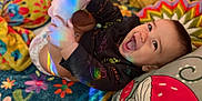 Lucas joined the competition — help win amazing prizes! baby, child, smiling, happy, foot, hand, blanket, cushion, colorful, rainbow, light, indoors, cute, playful, clothing, portrait, face, infant, toddler, cozy