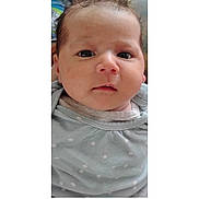 Iliana Yadimar is registered to the contest to win money with this photo: baby, infant, child, portrait, close_up, face, eyes, hair, serious_expression, curious, indoors, clothing, polka_dots, gray_outfit, head, cheeks, nose, mouth, photography, candid
