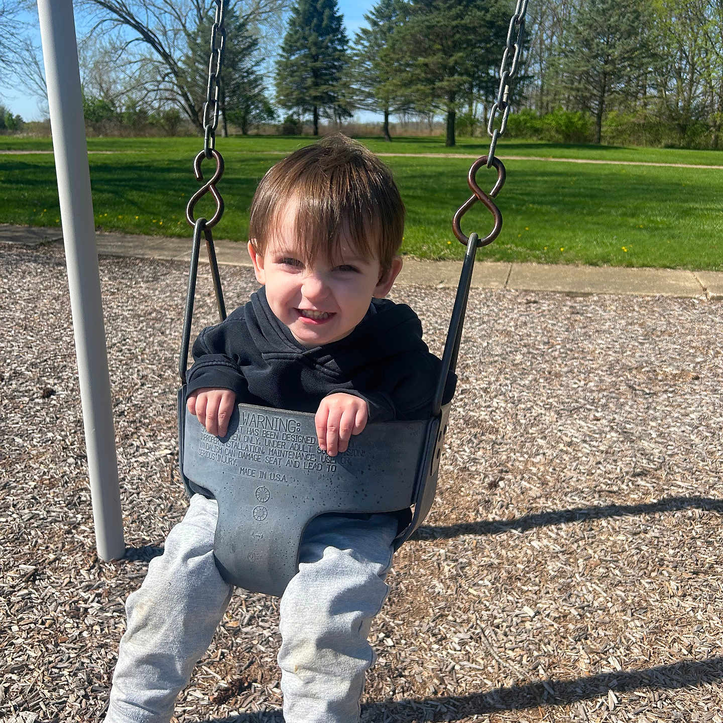 Karson joined the competition — help win amazing prizes! blue_sky, casual_clothing, child, daylight, fun, grass, happy, hoodie, leisure, nature, outdoor, park, person, playground, recreation, smiling, sneakers, swing, trees, young_child
